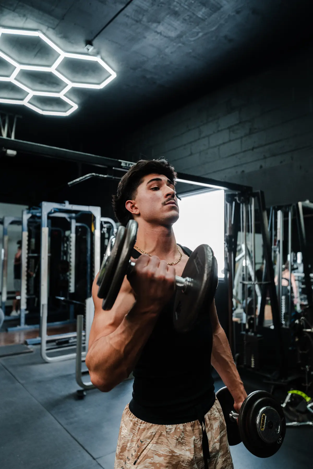 Dumbbell curls under hex lighting